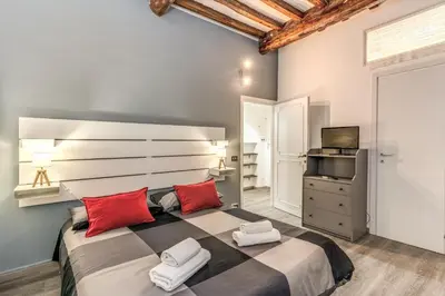 a bedroom with a large bed with red pillows at Monti Studio Roman Forum in Rome