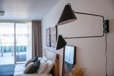 a lamp in a bedroom with a bed and a window at La Dolce Vita - Trastevere Luxury Stylish Studio in Rome