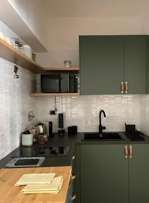 a kitchen with green cabinets and a sink at La Dolce Vita - Trastevere Luxury Stylish Studio in Rome