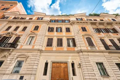 a large building with a wooden door and windows at Vittorio Emanuele Grand Apartment in Rome