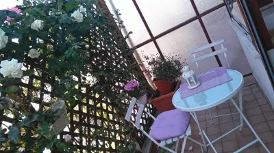 a table and a chair on a balcony with flowers at Il Punto in Rome