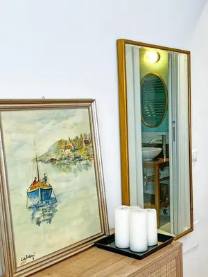 a painting of a boat in the water next to a mirror at Roma Parioli - Suite Mediterranea in Rome