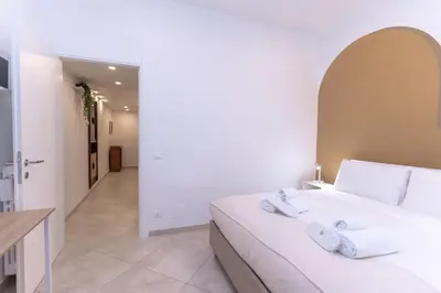 a bedroom with a white bed and a hallway at Casa Arco in Rome