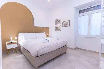 a bedroom with a large white bed with a window at Casa Arco in Rome