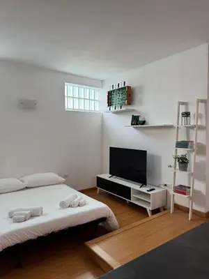 a white room with two beds and a flat screen tv at Splendido Attico con Terrazza a Trastevere in Rome