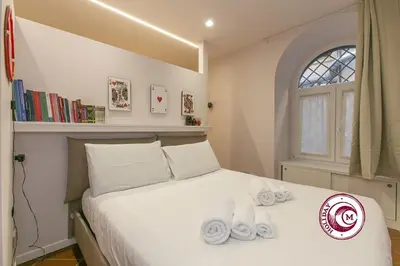 a bedroom with a bed with towels on it at C M Barberini Vacation in Rome
