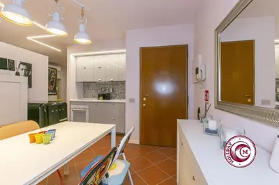a kitchen with a counter and a table in a room at C M Barberini Vacation in Rome