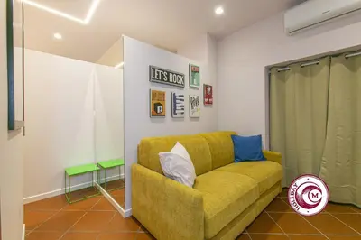 a living room with a yellow couch in a room at C M Barberini Vacation in Rome