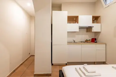 a kitchen with white cabinets and a refrigerator at Loft nel Cuore della Capitale in Rome