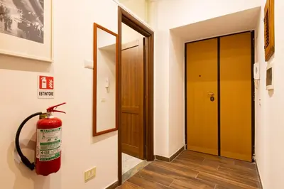 a fire hydrant hanging on a wall next to a door at Alma Musa Piazza Bologna Apartment in Rome
