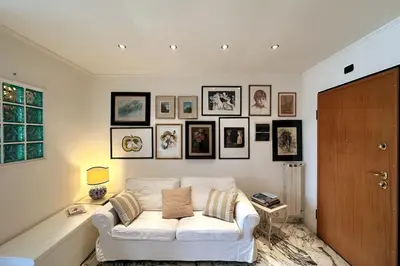 a living room with a white couch and pictures on the wall at The Vatican Studio in Rome