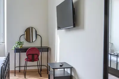 a bedroom with a red chair and a desk at iFlat Vatican New Bright & Comfy 3 Bedroom apt in Rome