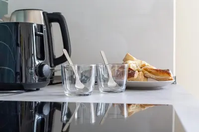 three glasses on a counter with a plate of food at iFlat Vatican New Bright & Comfy 3 Bedroom apt in Rome