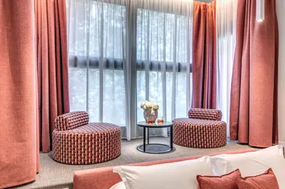 a living room with two chairs and a table and a window at Parioli Cube Hotel in Rome