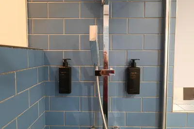 a blue tiled wall with three fire hydrants at Eclectic Apartment in Trendy San Lorenzo in Rome