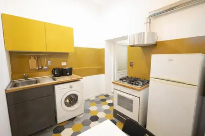 a small kitchen with a sink and a refrigerator at Eclectic Apartment in Trendy San Lorenzo in Rome