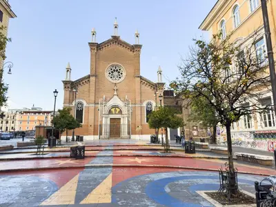 a large brick church with a clock tower at Eclectic Apartment in Trendy San Lorenzo in Rome