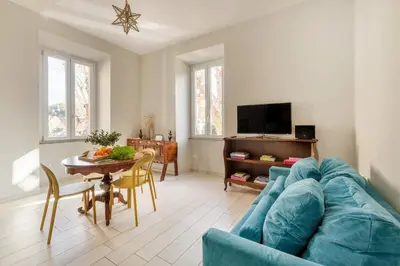a living room with a blue couch and a table at Green apartment Rome in Rome