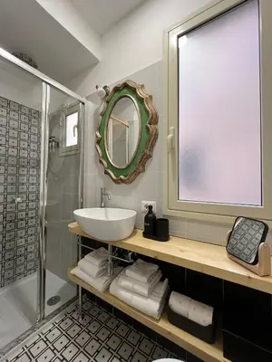 a bathroom with a sink and a shower and a mirror at Suite Crescenzio in Laterano in Rome