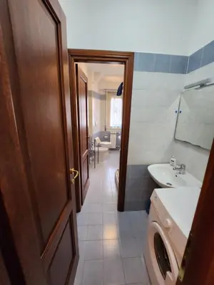 a bathroom with a toilet and a sink and a door at Al Gondar 7 Libia Roma in Rome