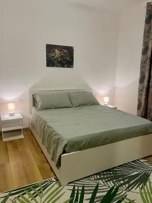 a bed in a white room with two lamps at Al lotto 27 Garbatella Storica in Rome