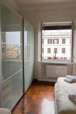 a bedroom with a bed and a large window at La Spezia House in Rome