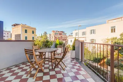 a patio with a table and chairs on a balcony at Modern Rooftop Apartment in Rome