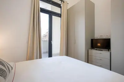 a white bedroom with a bed and a television at Urban Oasis with Terrace & free Parking, int11 in Rome