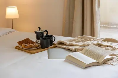 a white bed with a tray of food on it at Urban Oasis with Terrace & free Parking, int11 in Rome