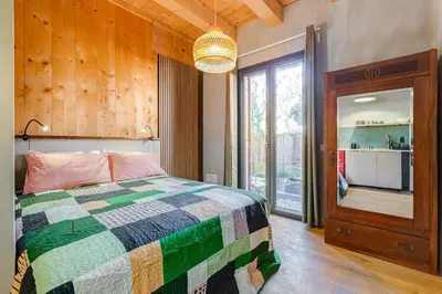 a bedroom with a bed and a large window at garden studio apartment in Rome