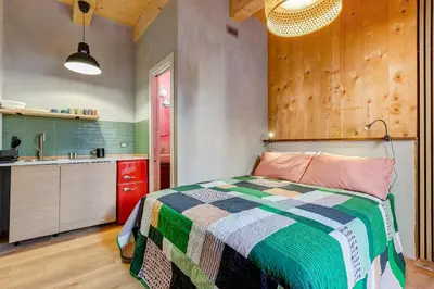 a bedroom with a bed and a kitchen with a sink at garden studio apartment in Rome