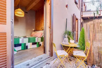 a balcony with a table and chairs and a bed at garden studio apartment in Rome