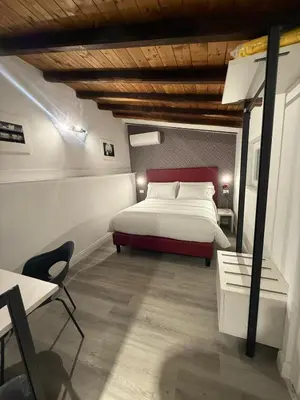 a bedroom with a bed and a table and a chair at FoffoSuite in Rome