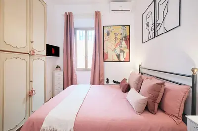 a bedroom with a large pink bed with pink pillows at NEW - La Casetta di Nadia in Rome