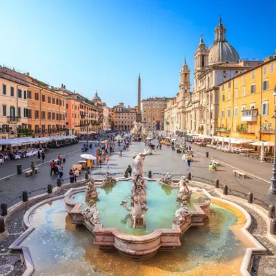 a street with a fountain in the middle of a city at Regina Cappellari - Elegante dimora nel cuore di Roma in Rome
