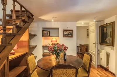 a dining room with a table with a vase of flowers at Corso Vittorio top location in Rome