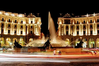 a fountain in front of a building at night at NEXT Palace in Rome
