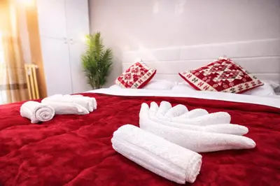 a bed with towels and pillows on a red blanket at NEXT Palace in Rome