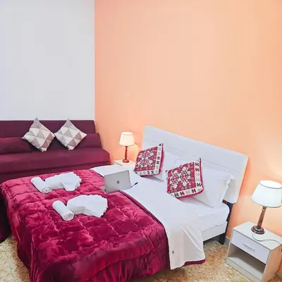 a bedroom with a bed and a red couch at NEXT Palace in Rome