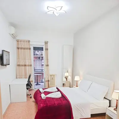a bedroom with a white bed with a red blanket at NEXT Palace in Rome
