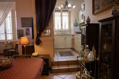 a room with a kitchen with a table and a bed at Antonietta's Home in Rome