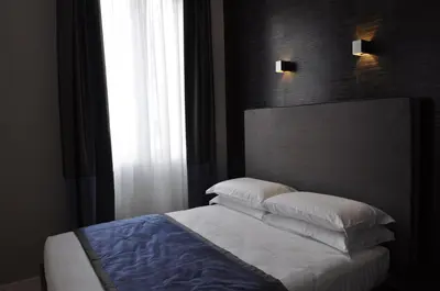 a bedroom with a bed with pillows and a window at Place 24 Suites & Wellness in Rome