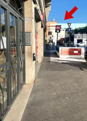 an empty sidewalk in front of a building with a red arrow at Panoramic penthouse 10m from metro A in Rome