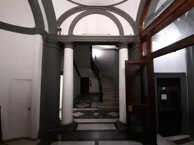 a hallway with white columns and a spiral staircase at Stradivari in Rome