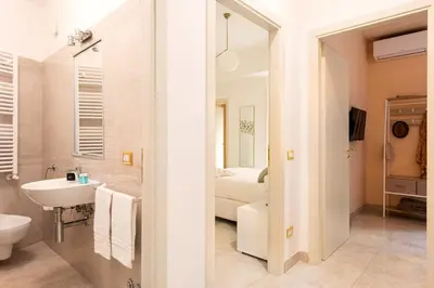 a white bathroom with a sink and a toilet at Idyllia - Spacious bright flat in Rome