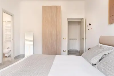 a white bedroom with a bed and a bathroom at Idyllia - Spacious bright flat in Rome