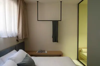 a bedroom with a bed and a lamp on the wall at ATEL Guest House in Rome