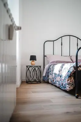 a bedroom with a bed and a lamp on a wooden floor at Domus Iulia, Trastevere in Rome