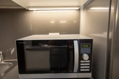 a microwave oven in a kitchen with a clock on it at Deluxe Spanish Steps in Rome