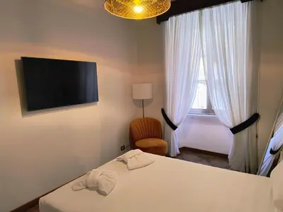 a room with two beds and a tv and a window at The Apartment in Rome